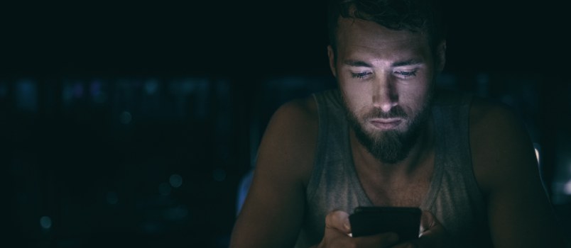 Man texting on phone in night