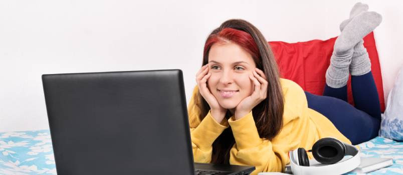 woman looking at the laptop screen and smiling