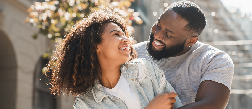 Couple affectueux s'embrassant dans une rue urbaine ensoleillée