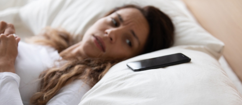 Frightened Woman Lying In Bed Looking On Smartphone Feels Afraid And Scared