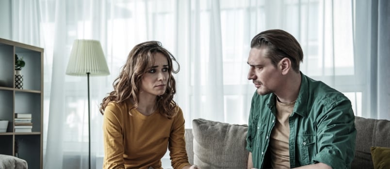 Upset Couple Is Sitting On Sofa And Looking At Each Other Pensively