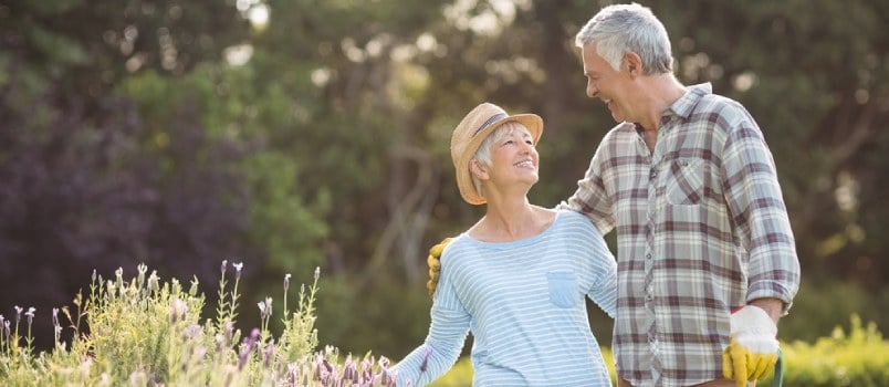 Happy Senior Couple Standing In Backyard