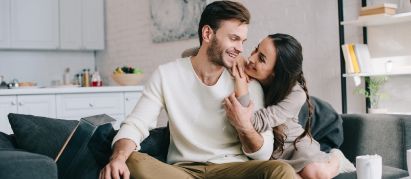 Beautiful Young Couple Listening Music With Vinyl Phonograph And Cuddling On Couch