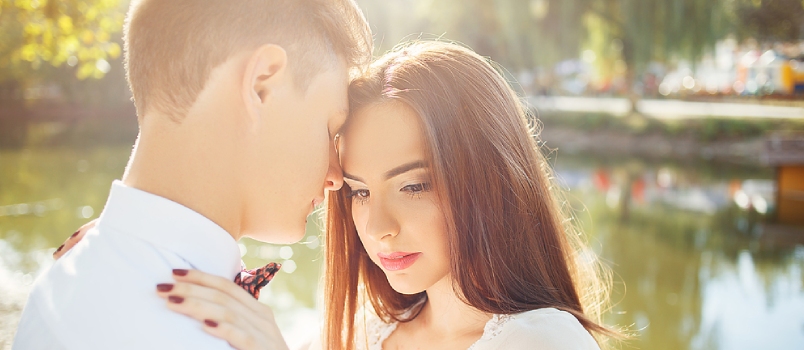 Thoughtful Lovers Feeling Upset Together At Bank Of Pond In Garden