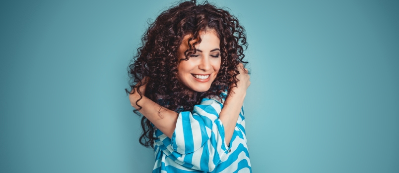 Closeup Portrait Confident Smiling Woman Holding Hugging Herself Isolated Blue Wall Background
