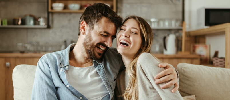 Young Happy Couple Having Fun While Talking About Something Funny At Home