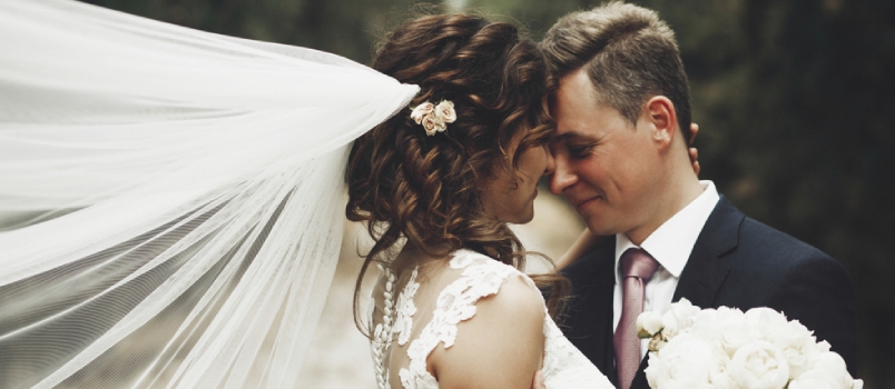 Groom Hugs Bride Tender While Wind Blows Her Veil Somewhere