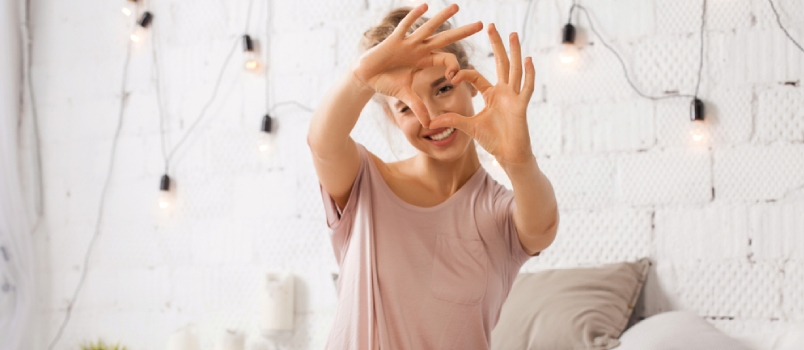 Women With Heart Symbol Finger Sitting On The Bed At Bedroom And Smiling In Love