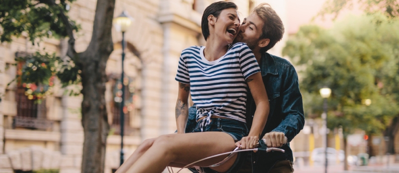 Laughing Woman Sitting On Boyfriends Bicycle Handlebar Cheerful Couple On A Bike Together In The City Having Fun