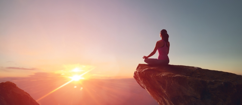 Woman Practices Yoga And Meditates On The Mountain Sun Is Rising Infront