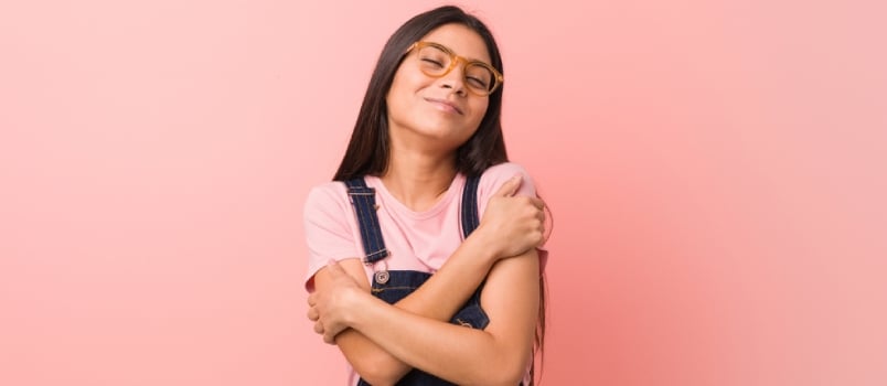 Young Pretty Arab Woman Wearing A Jeans Dungaree Hugs, Smiling Carefree And Happy