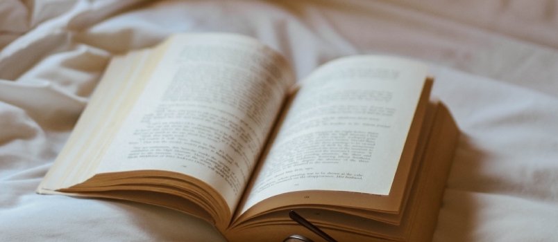 Eyeglasses Beside Book And Rings