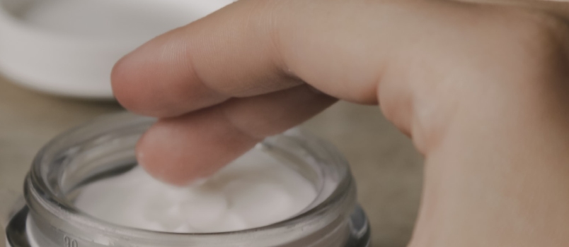 Person Finger Touching Moisturizer Cream