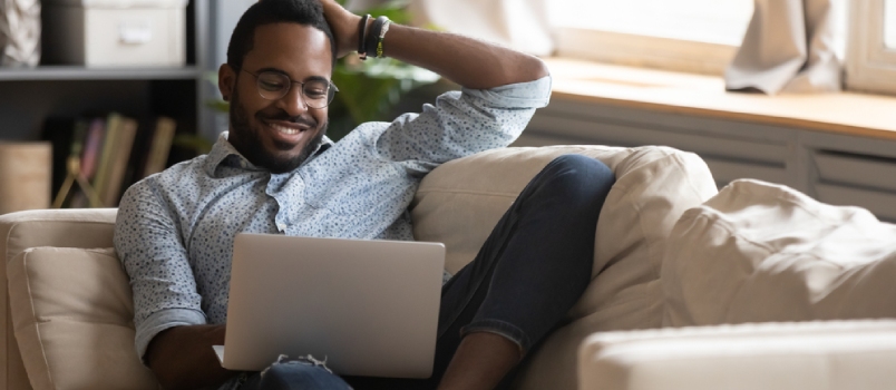 Full Length Dreamy Young Mixed Race Guy Dating Online In Social Network Or Chatting With Girlfriend Alone At Home