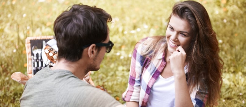 Couple Smiling And Gossip Together On Picnic In The Park