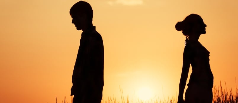 Couple Standing Against The Sunset Back To Back