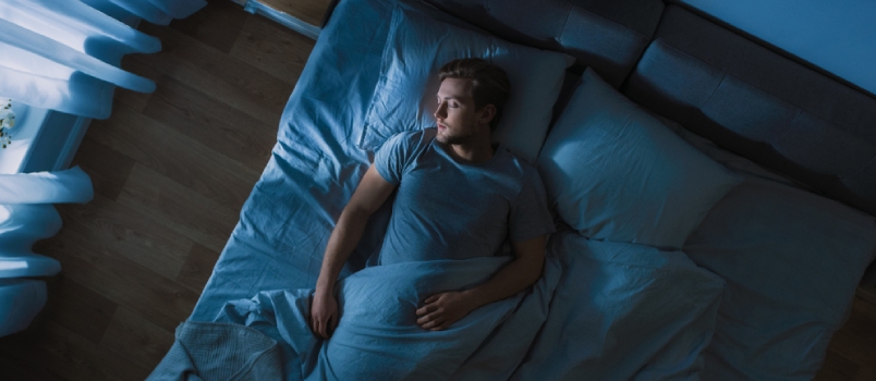 Young Man Sleeping Cozily On A Bed In His Bedroom At Night Top View Picture