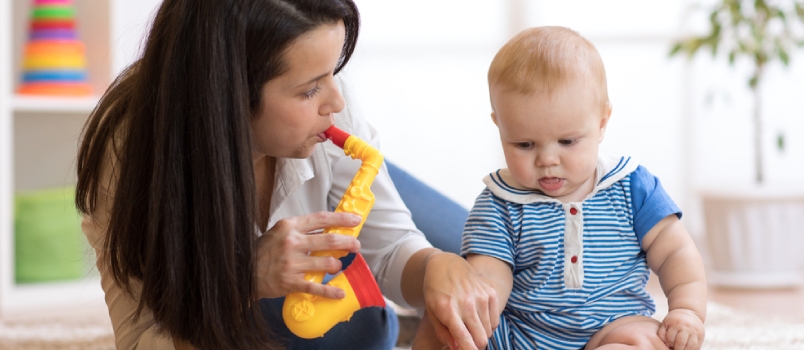 Woman And Baby Playing Musical Toys In Nursery