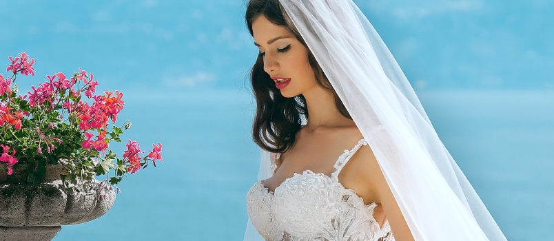 Woman In Wedding Dress While Holding Flower During Daytime