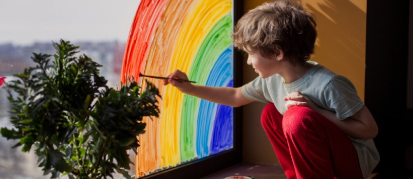 Child At Home Draws A Rainbow On The Window