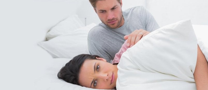 mulher furiosa fingindo dormir enquanto o marido a convence