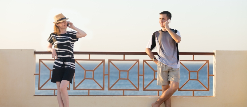 Minimalistic Portrait Of Young Happy Smiling Couple, Man And Woman Holding Cellphones