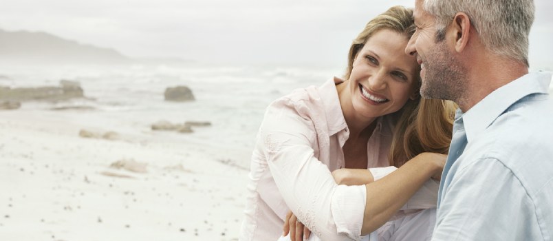 Middle-aged Couple On Beach Sitting Together And Smiling Happy Love Couple On Holiday