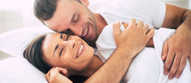 happy couple hugging while in bed
