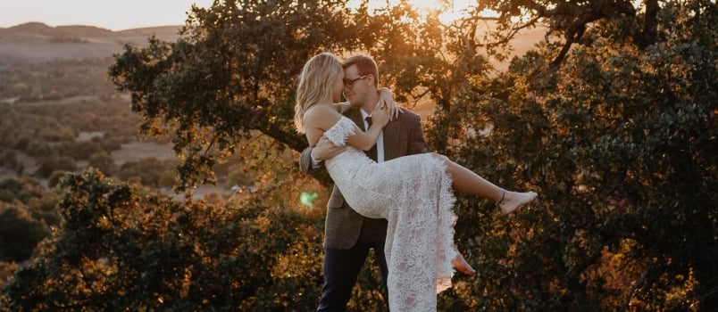 Man Holding Women Up In Hand And Having Romance Outdoor At Hill With Nature