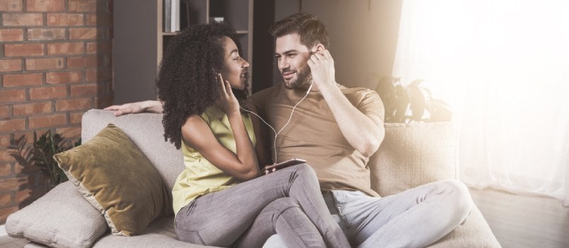 Attractive Couple Listing Music With Shared One Earphone