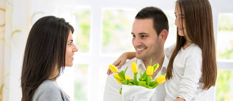 Husband And Daughter Giving Her Women A Flowers Bookey On Mothers Day Occasion