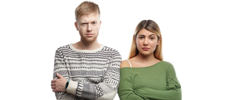Horizontal Shot Of Distrustful Young Couple Crossing Arms In Studio And Staring At Camera, Having Doubtful Skeptical Looks