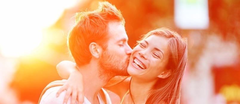 Young Attractive Man Kissing His Girlfriend While Walking In The City