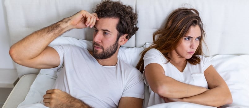 Top View Of Young Couple Lying On The Bed. Couple Having A Fight In The Bed. Concept About Relationship And Problems Between Couples.