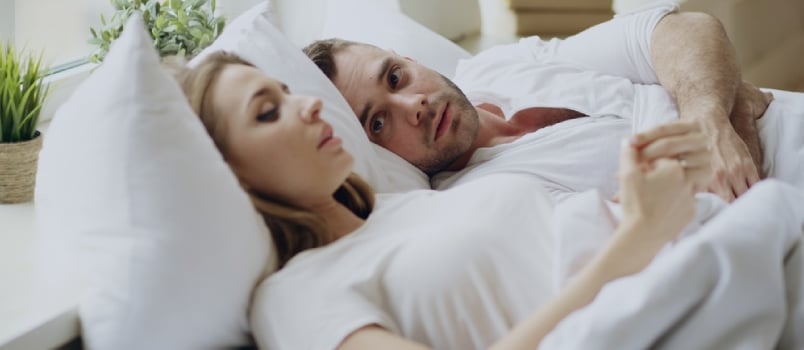 Closeup Of Couple With Relationship Problems Having Emotional Conversation While Lying In Bed At Home