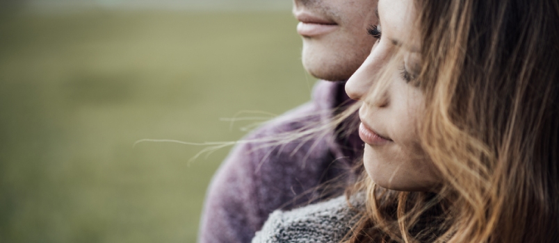 Young Loving Couple Outdoors Sitting On Grass, Hugging And Looking Away, Future And Relationships Concept