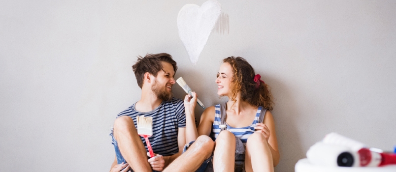 Young Couple In Love Painting Walls In Their New Home. Lady Brushing Men's Nose In Love