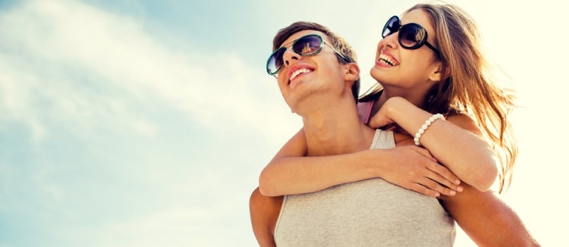 Smiling Couple Having Fun Over Sky Background- Holidays, Vacation, Love And Friendship Concept