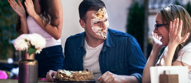 Three Grown Up Are Celebrating Birthday On The Terrace And A Birthday Boy's Face Is Dirty With Whipped Cake Cream