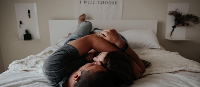 Young Attractive Couple Lying Together On Bed Having Romance At Bedroom