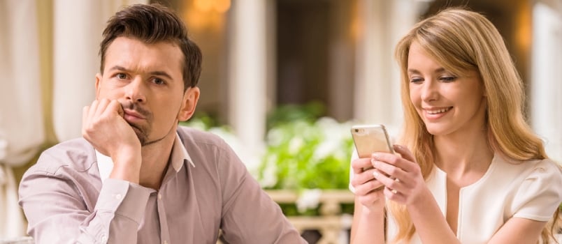 Man Is Getting Bored In Restaurant While His Woman Looking At Phone