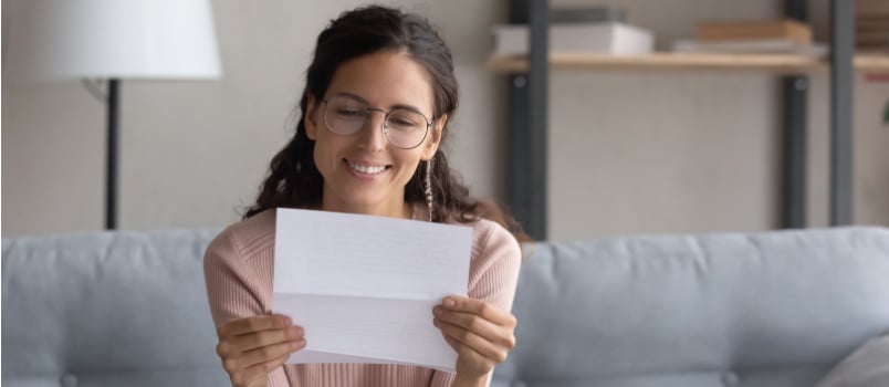 Woman smiling while reading the letter
