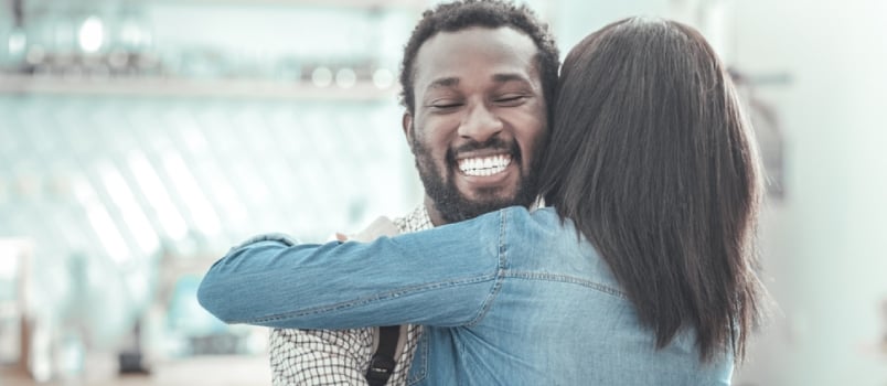 Joyful Positive Nice Man Smiling And Hugging His Friend While Meeting