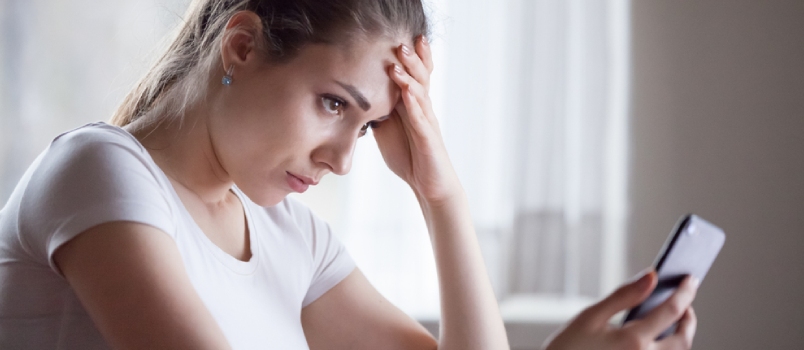 Angry Young Woman Looking At Smartphone Frustrated By No Signal Or Scam Message