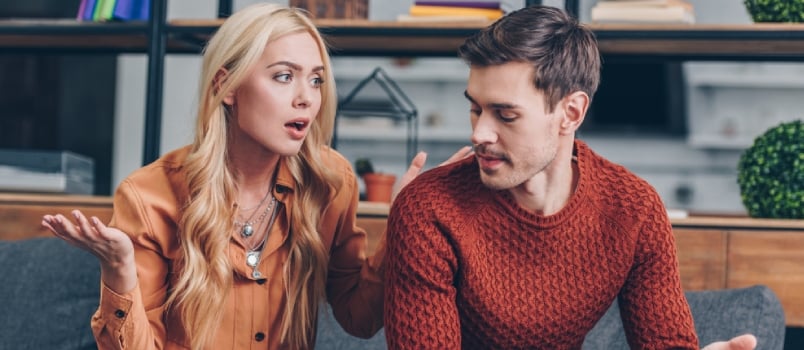 Emotional Upset Couple Sitting On Couch And Quarreling About Smartphone, Mistrust Concept