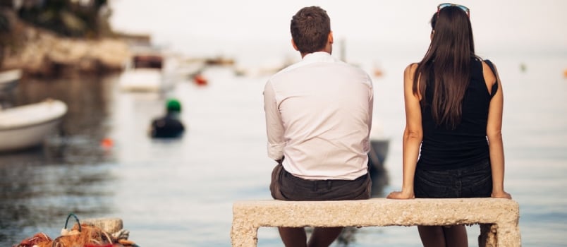 Romantic Couple On A Date In Nature, Sitting On The Bench Looking At Serene Ocean Scene