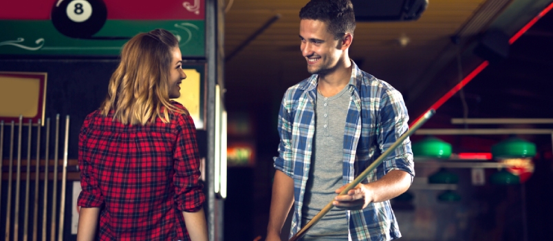 Couple Dating, Flirting, And Holding Billiard In A Pool Stick In The Hall