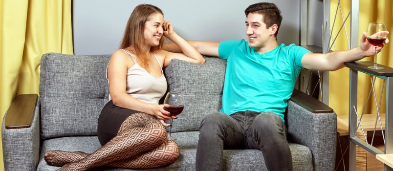 Young Passonate Couple Having Conversation Together On Sofa At The Living Room