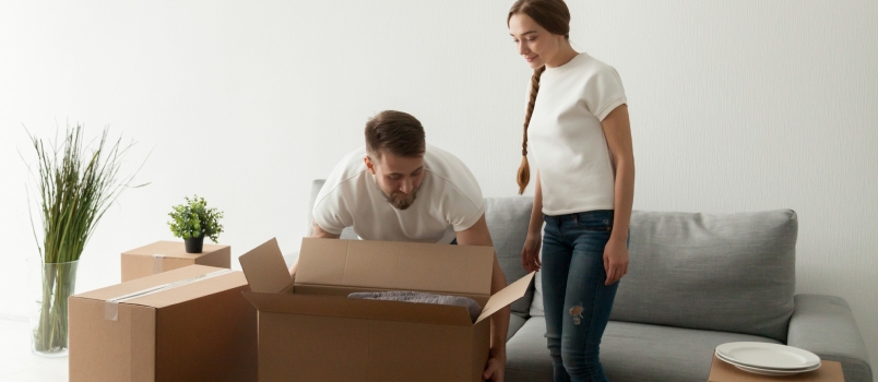 Young Spouses Carrying Boxes Relocating To New Flat