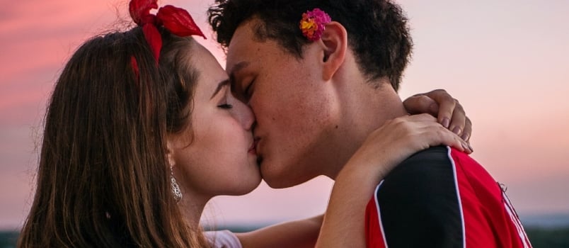 Young Male And Female Kissing Together